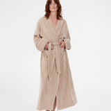 Oversize beige badekåbe i 100% økologisk bomuld. Josefinemd bathrobe har store lommer, bindebånd og kontrastkanter, der giver den et elegant touch. Badekåben har et fint og diskret logo på ryggen. Perfekt til hyggelige morgener. Josefine Vogt (165 cm) og modellen (177 cm) har begge størrelse Small på.