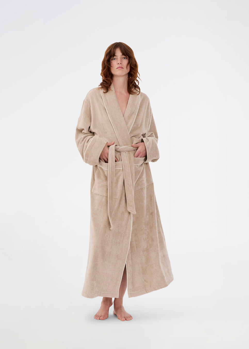 Oversize beige badekåbe i 100% økologisk bomuld. Josefinemd bathrobe har store lommer, bindebånd og kontrastkanter, der giver den et elegant touch. Badekåben har et fint og diskret logo på ryggen. Perfekt til hyggelige morgener. Josefine Vogt (165 cm) og modellen (177 cm) har begge størrelse Small på.