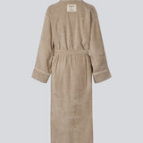 Oversize beige badekåbe i 100% økologisk bomuld. Josefinemd bathrobe har store lommer, bindebånd og kontrastkanter, der giver den et elegant touch. Badekåben har et fint og diskret logo på ryggen. Perfekt til hyggelige morgener. Josefine Vogt (165 cm) og modellen (177 cm) har begge størrelse Small på.