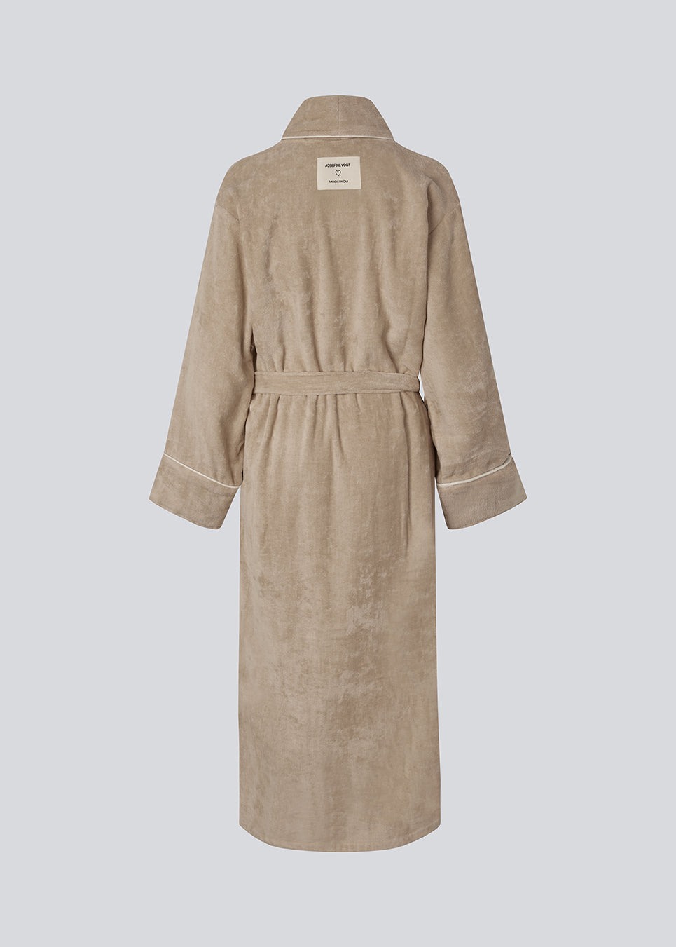Oversize beige badekåbe i 100% økologisk bomuld. Josefinemd bathrobe har store lommer, bindebånd og kontrastkanter, der giver den et elegant touch. Badekåben har et fint og diskret logo på ryggen. Perfekt til hyggelige morgener. Josefine Vogt (165 cm) og modellen (177 cm) har begge størrelse Small på.