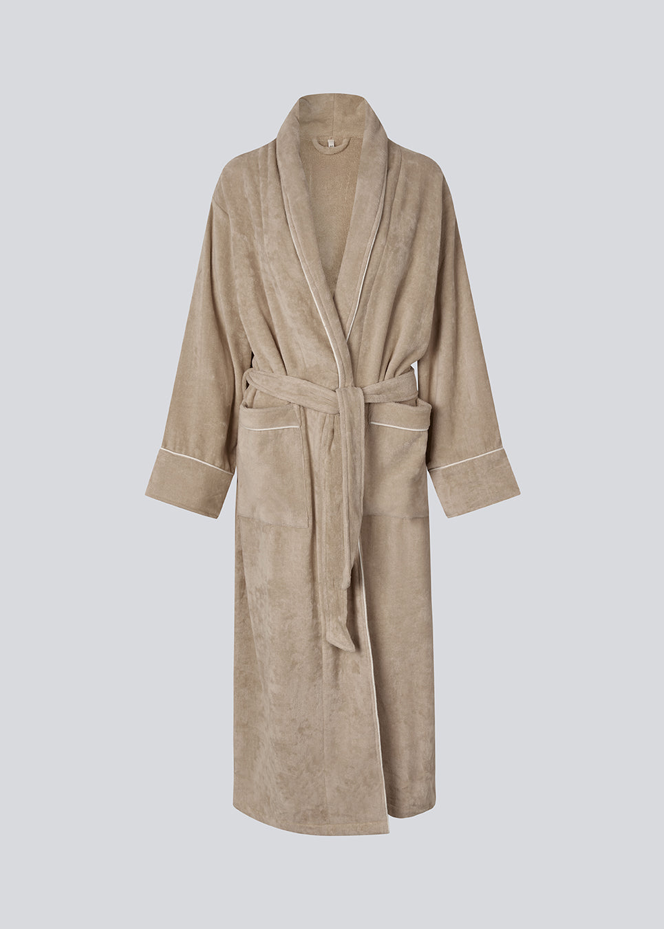 Oversize beige badekåbe i 100% økologisk bomuld. Josefinemd bathrobe har store lommer, bindebånd og kontrastkanter, der giver den et elegant touch. Badekåben har et fint og diskret logo på ryggen. Perfekt til hyggelige morgener. Josefine Vogt (165 cm) og modellen (177 cm) har begge størrelse Small på.