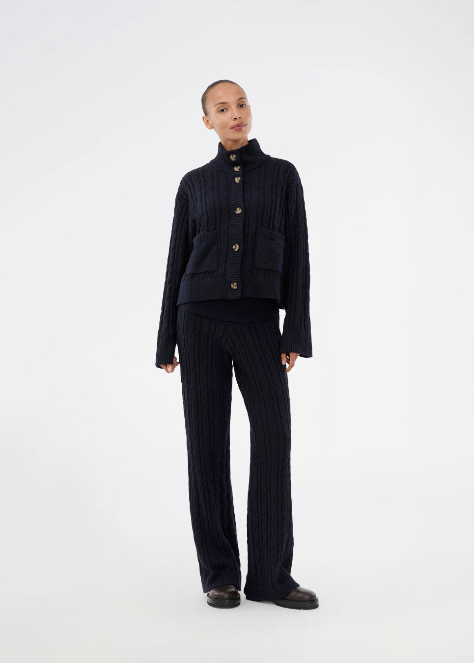 Højhalset cardigan. Josefinemd knit cardigan er kabelstrikket med høj hals, manchetknapper og lommer. Tidløs og perfekt til kølige dage, eller som layering over kjoler og toppe.&nbsp;
Josefine Vogt (165 cm) og modellen (177 cm) har begge størrelse Small på.
