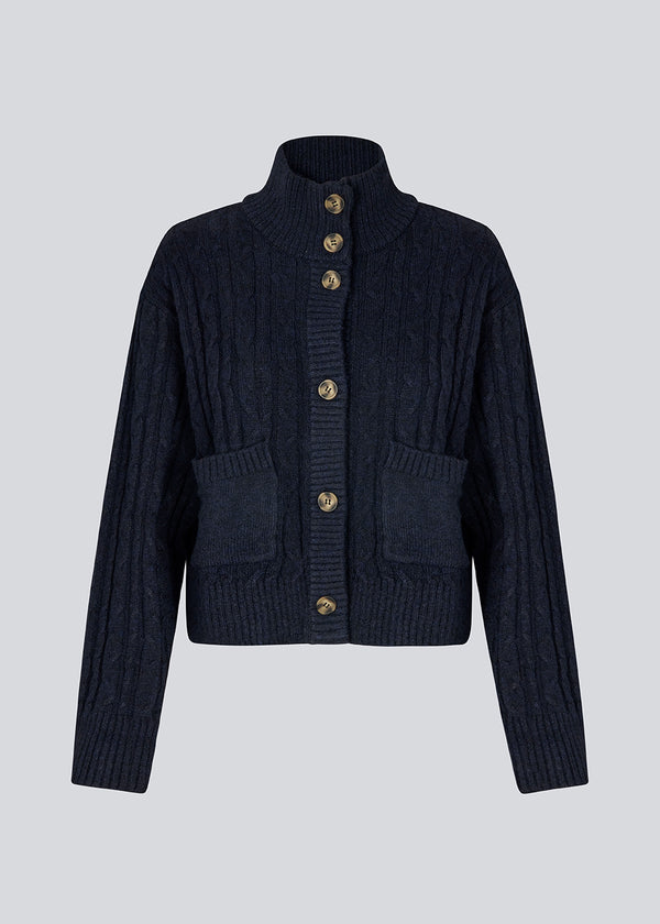 Højhalset cardigan. Josefinemd knit cardigan er kabelstrikket med høj hals, manchetknapper og lommer. Tidløs og perfekt til kølige dage, eller som layering over kjoler og toppe.&nbsp;
Josefine Vogt (165 cm) og modellen (177 cm) har begge størrelse Small på.