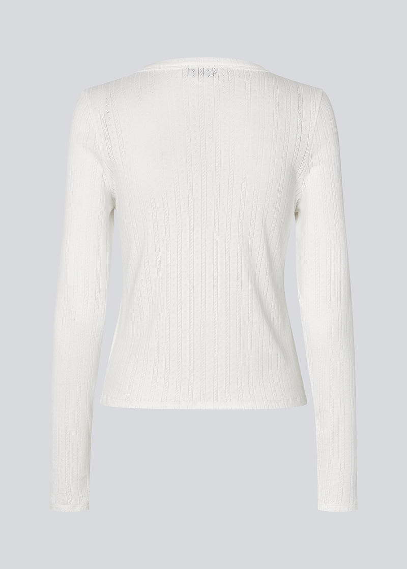 Længærmet pointelle t-shirt. Josefinemd LS t-shirt en tætsiddende t-shirt i pointelle bomuld med blondekant. Feminint snit og diskret hulmønster giver den klassiske style et let, elegant touch. Josefine Vogt (165 cm) og modellen (177 cm) har begge størrelse Small på.