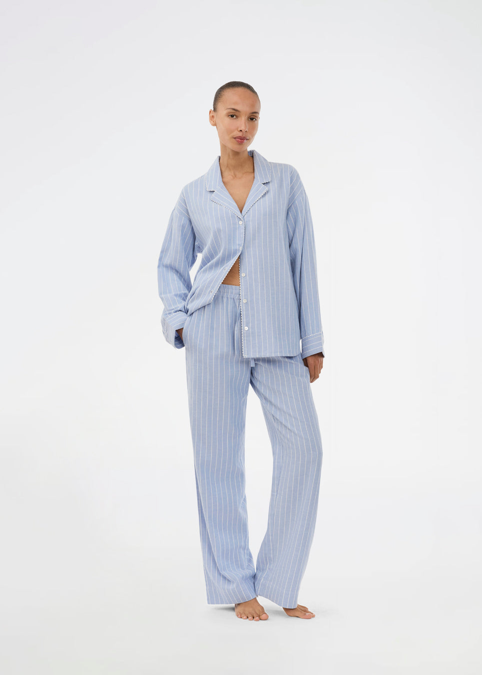 Blåt stribet pyjamas sæt i 100% bomuld. Pyjamas sælges samlet i to dele, skjorte og bukser. Josefinemd pyjamas har et klassisk fit med krave, knaplukning og snørre i bukserne. Sættet har en fin bølgekant og leveres med en matchende pose med logo. Det er ikke muligt at købe forskellige størrelser over- og underdel.&nbsp;