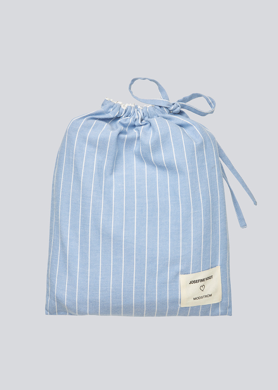 Blåt stribet pyjamas sæt i 100% bomuld. Pyjamas sælges samlet i to dele, skjorte og bukser. Josefinemd pyjamas har et klassisk fit med krave, knaplukning og snørre i bukserne. Sættet har en fin bølgekant og leveres med en matchende pose med logo. Det er ikke muligt at købe forskellige størrelser over- og underdel.&nbsp;