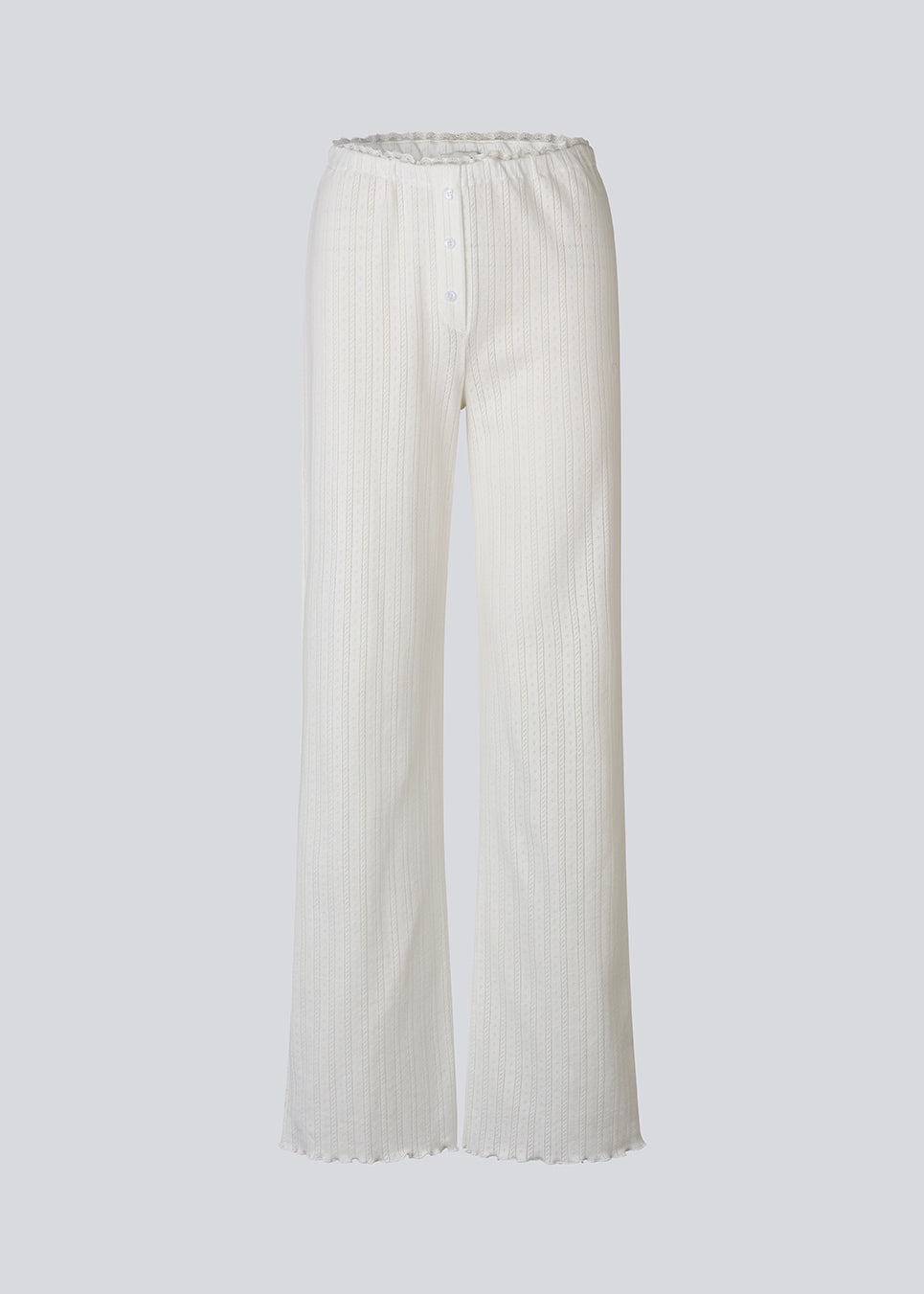 Ponitelle bukser. Josefinemd pants er feminine bukser i pointelle-bomuld med blondekant og diskret hulmønster. Blødt materiale og høj komfort gør dem perfekte til afslapning. Josefine Vogt (165 cm) og modellen (177 cm) har begge størrelse Small på.