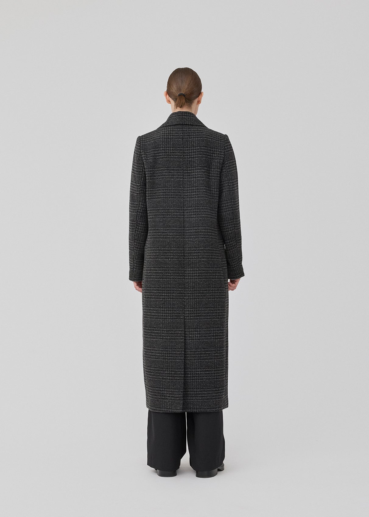 Klassisk, dobbeltradet uldfrakke i mørkegrå med krave og revers. JuniperMD check coat har en afslappet pasform, foer og en slids bagpå.