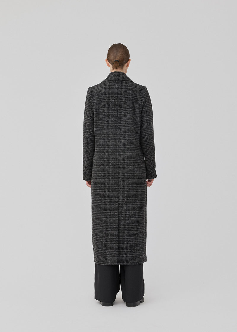 Klassisk, dobbeltradet uldfrakke i mørkegrå med krave og revers. JuniperMD check coat har en afslappet pasform, foer og en slids bagpå.