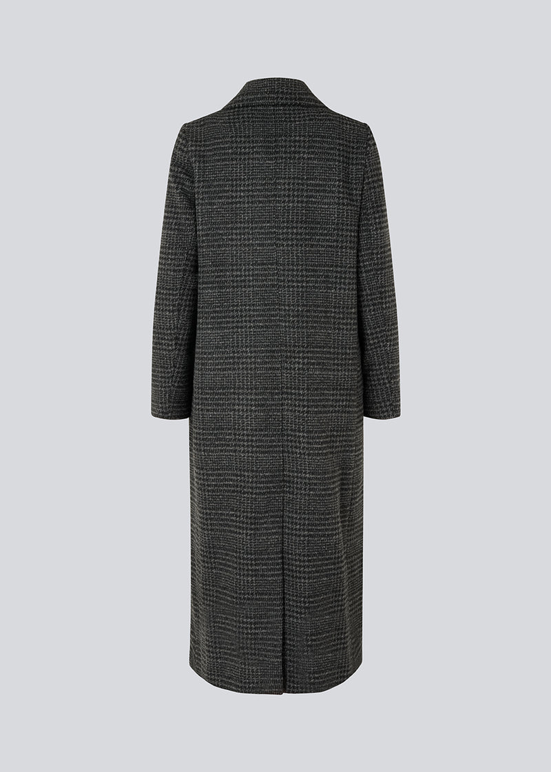 Klassisk, dobbeltradet uldfrakke i mørkegrå med krave og revers. JuniperMD check coat har en afslappet pasform, foer og en slids bagpå.