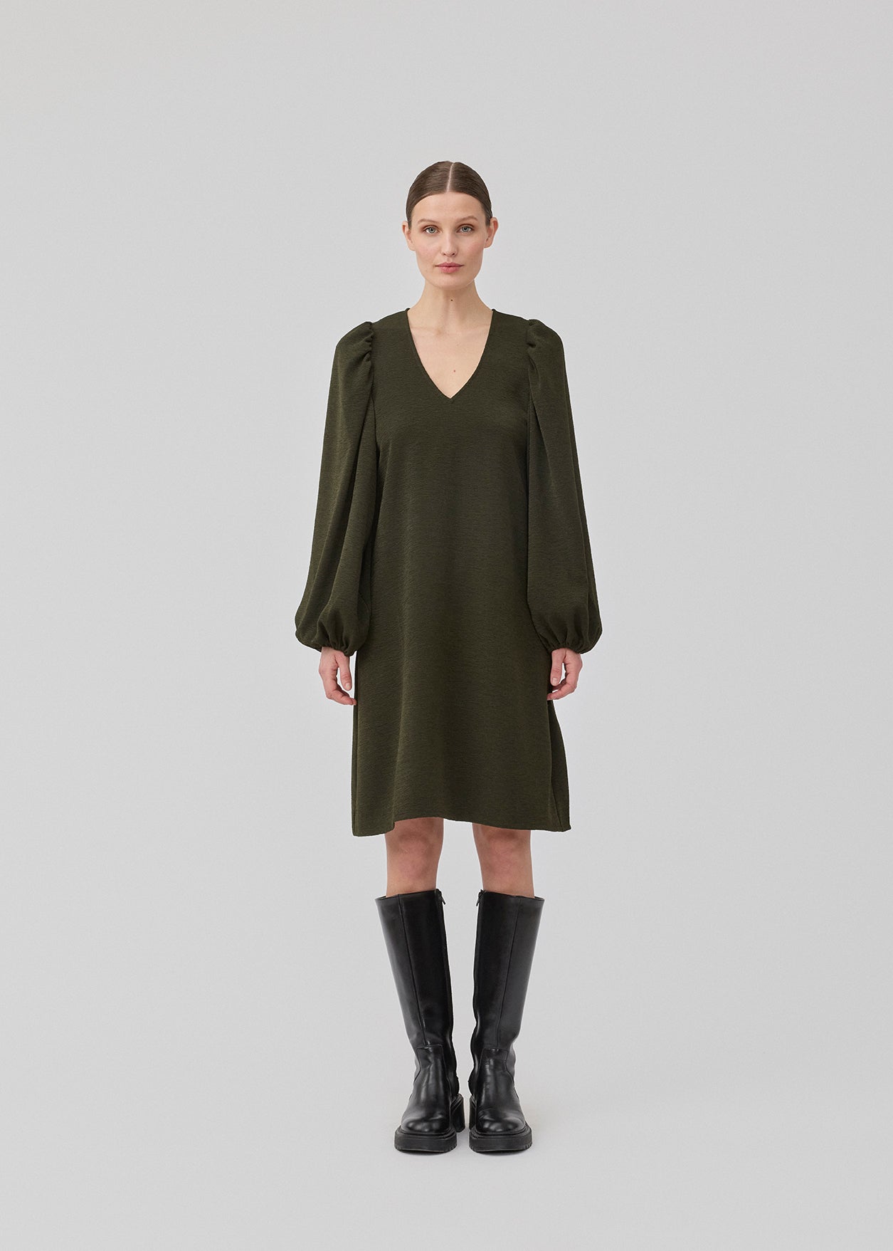 Kort mørkegørn kjole i et let struktureret materiale. KarliMD short dress har pufærmer og en V-udskæring.