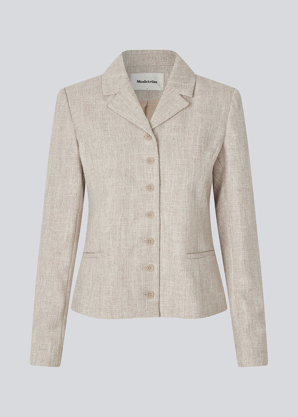 Vores meget populære Kiera jakkesæt er tilbage i en ny sommer-farve.
Kort figursyet blazer i beige melange i et tykt struktureret materiale. KieraMD jacket har knappelukning, to lommer foran og en slids i ærmet som spændes med knapper.