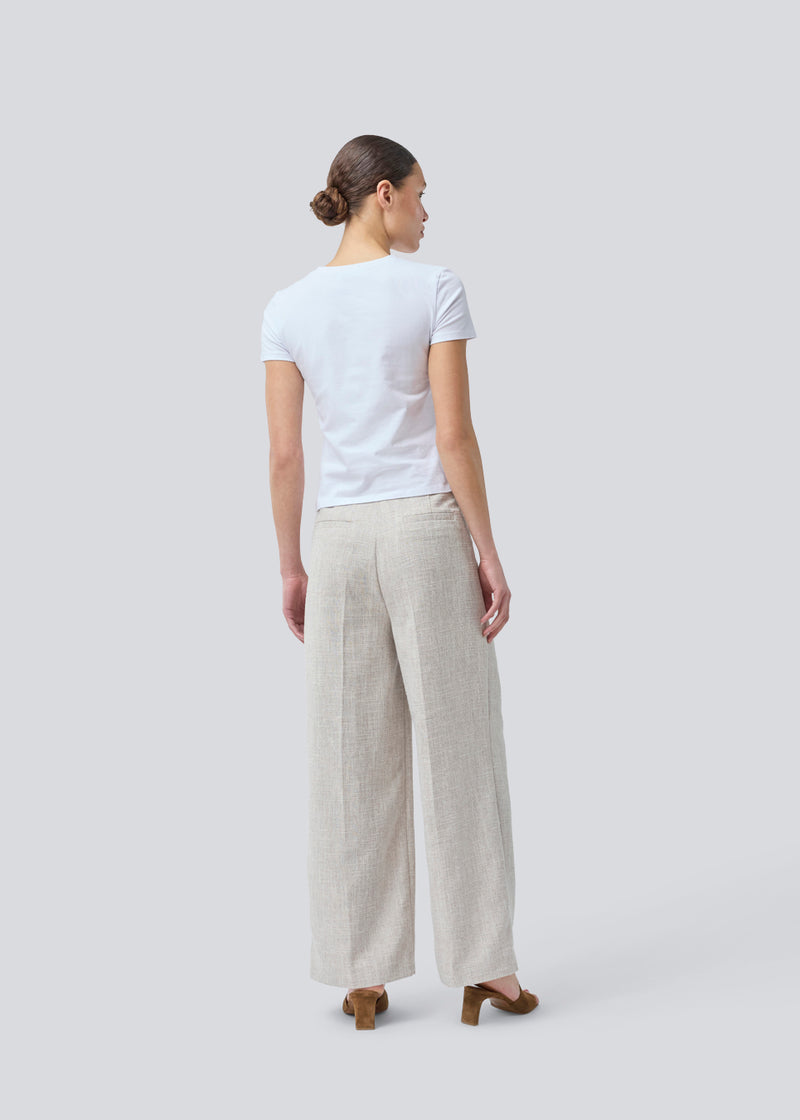 Vores meget populære Kiera jakkesæt er tilbage i en ny sommer-farve.
Habitbukser i beige melange i struktureret materiale med vide ben. KieraMD pants har en høj talje, lynlåsgylp og pressefolder, samt sidelommer og paspolerede baglommer.