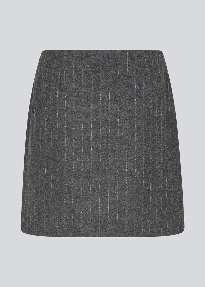 Kort mørkegrå stribet nederdel i uldblanding. KristolMD skirt har foer og en usynlig lynlås i siden. Modellen er 175 cm og bruger størrelse S.
