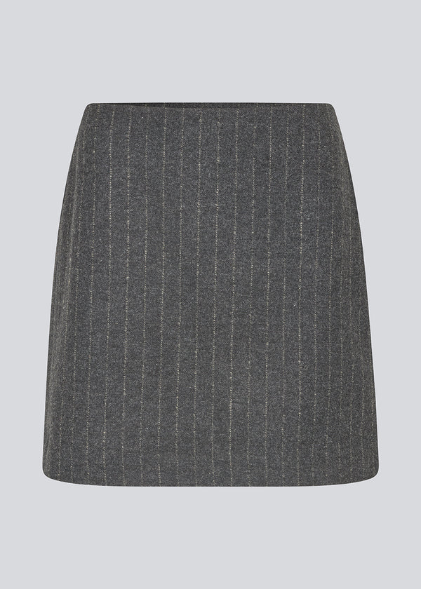 Kort mørkegrå stribet nederdel i uldblanding. KristolMD skirt har foer og en usynlig lynlås i siden. Modellen er 175 cm og bruger størrelse S.