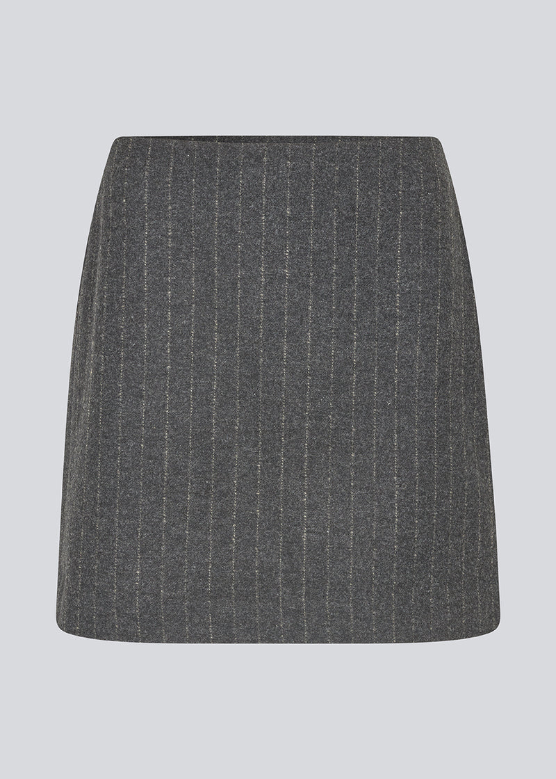 Kort mørkegrå stribet nederdel i uldblanding. KristolMD skirt har foer og en usynlig lynlås i siden. Modellen er 175 cm og bruger størrelse S.