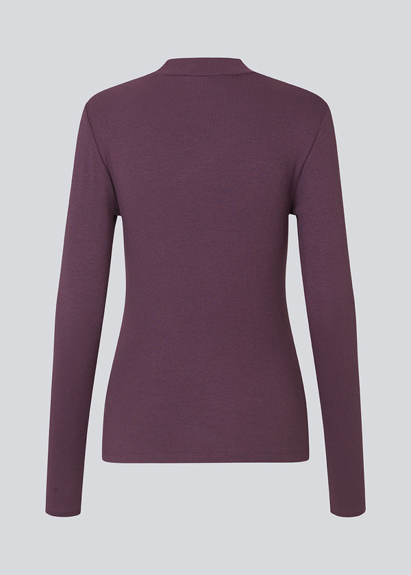 Lilla langærmet t-shirt med høj hals. Krown LS t-neck er i rib kvalitet og er tætsiddende i pasformen. Trøjen er i en lækker EcoVero viskose kvalitet.
