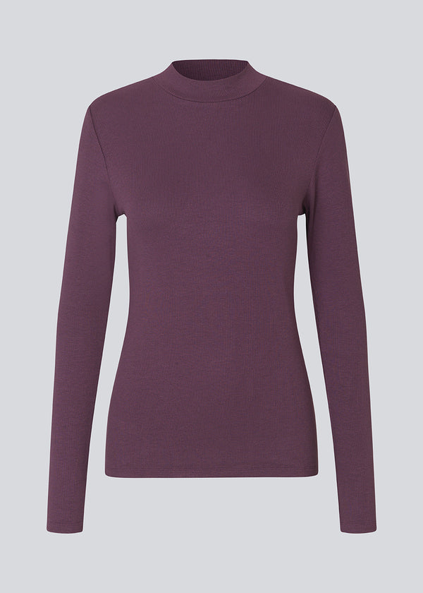 Lilla langærmet t-shirt med høj hals. Krown LS t-neck er i rib kvalitet og er tætsiddende i pasformen. Trøjen er i en lækker EcoVero viskose kvalitet.
