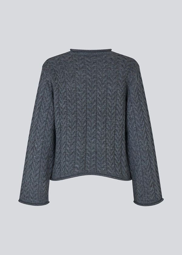 Løs strik med brede ærmer i kabel strik. KurtisMD v-neck har en rund halsudskæring og rullede detaljer på ærmerne og halsen.