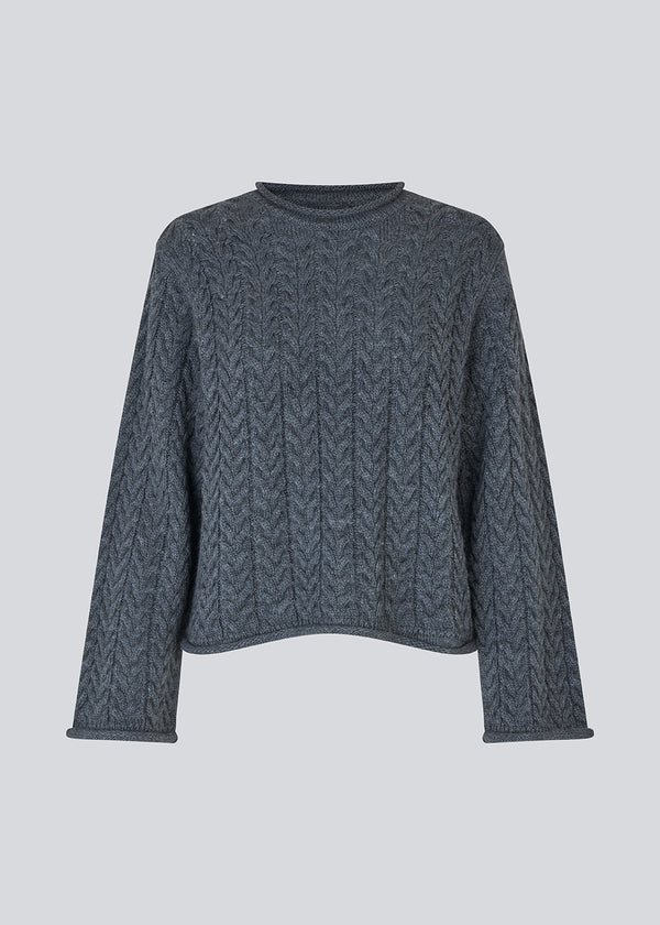 Løs strik med brede ærmer i kabel strik. KurtisMD v-neck har en rund halsudskæring og rullede detaljer på ærmerne og halsen.