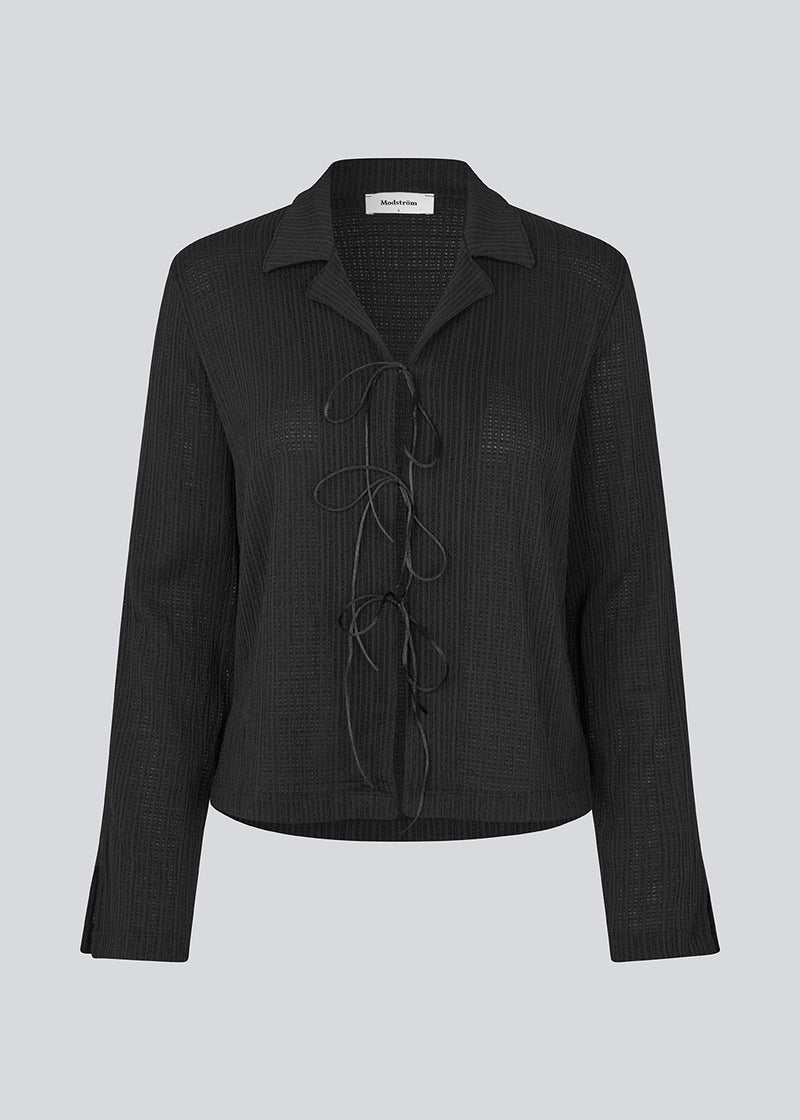 Klassisk skjorte med bindebånds lukning i et elastisk og let gennemsigtigt materiale. LaceyMD shirt har brede ærmer og tre bindebånd fortil.