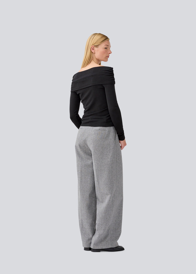 Sort off shoulder top i et elastisk materiale. LillianMD top er figursyet og har lange tætsiddende ærmer. Modellen er 177 cm og har en størrelse S/36 på.