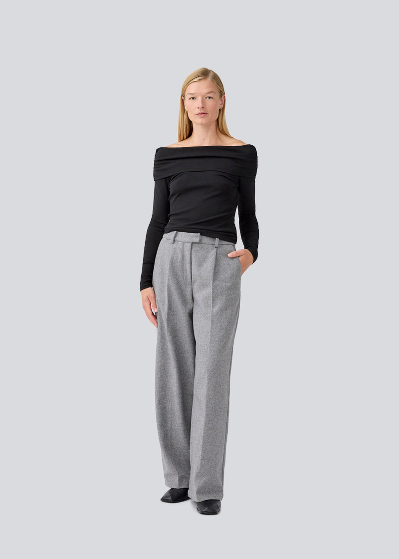 Sort off shoulder top i et elastisk materiale. LillianMD top er figursyet og har lange tætsiddende ærmer. Modellen er 177 cm og har en størrelse S/36 på.