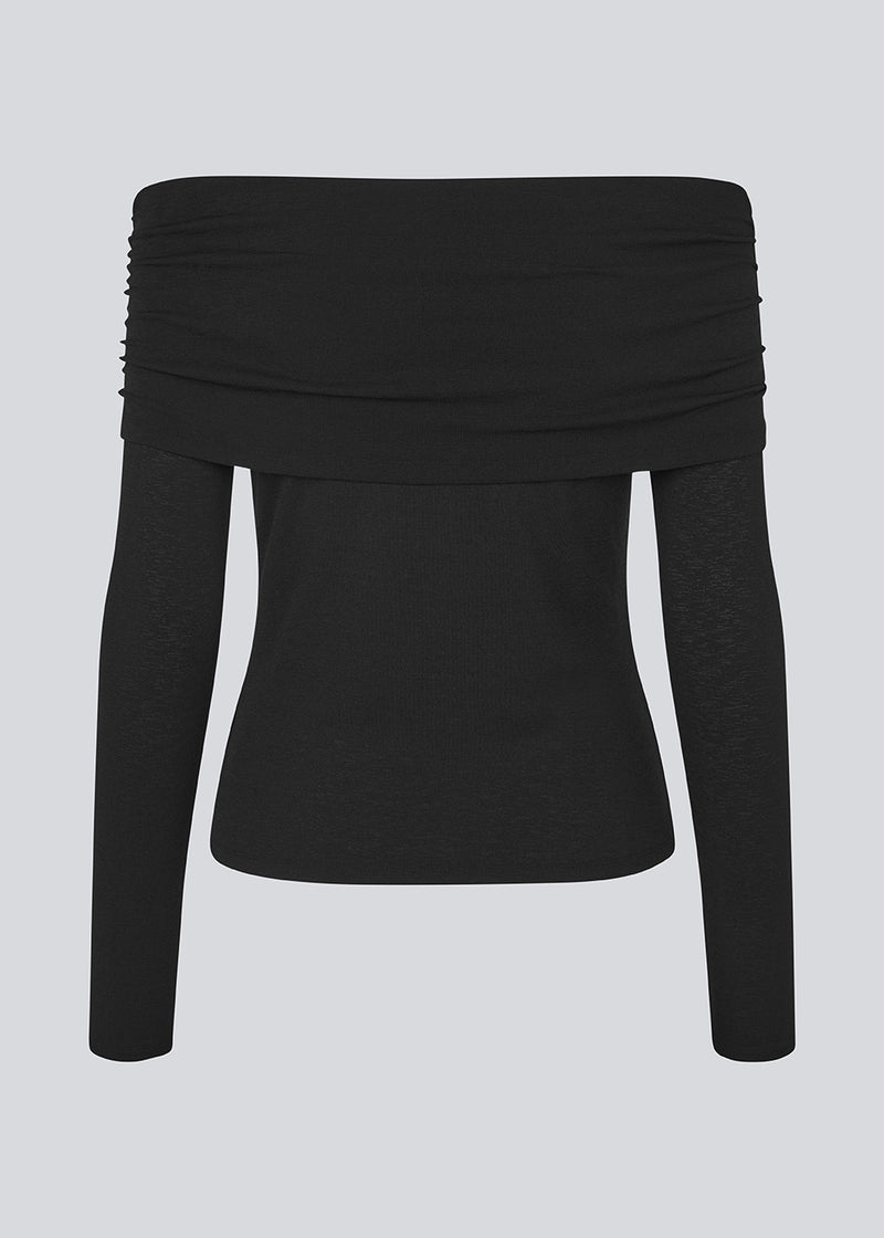 Sort off shoulder top i et elastisk materiale. LillianMD top er figursyet og har lange tætsiddende ærmer. Modellen er 177 cm og har en størrelse S/36 på.