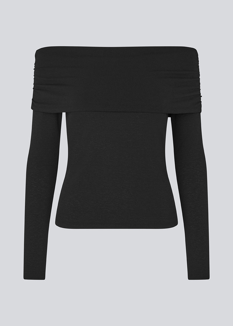 Sort off shoulder top i et elastisk materiale. LillianMD top er figursyet og har lange tætsiddende ærmer. Modellen er 177 cm og har en størrelse S/36 på.