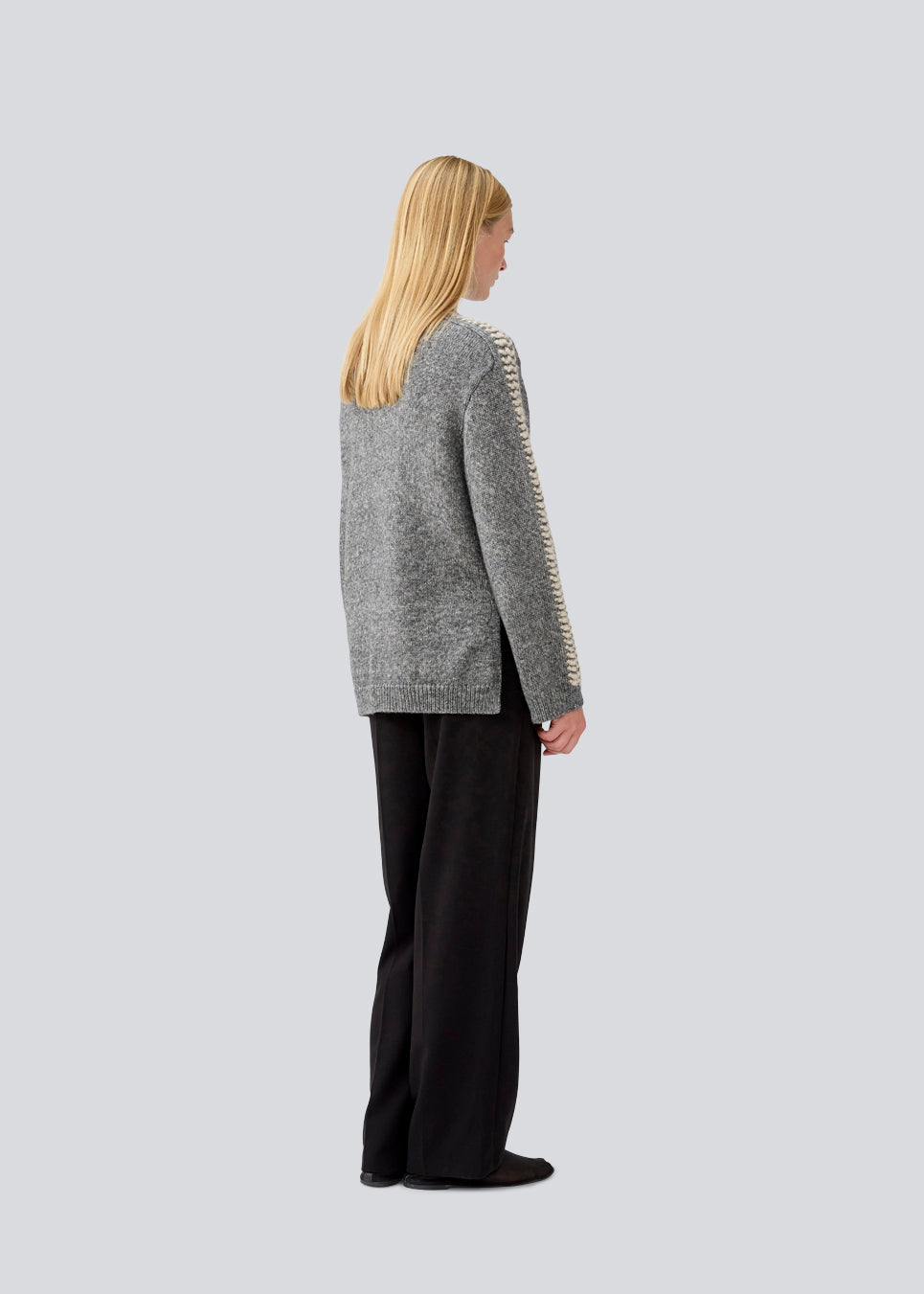 Blød mørkegrå strik med beige detalje på ærmet. LineMD o-neck har en rund hals og en løs pasform, samt slidser i siderne. Modellen er 177 cm og har en størrelse S/36 på.