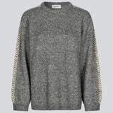 Blød mørkegrå strik med beige detalje på ærmet. LineMD o-neck har en rund hals og en løs pasform, samt slidser i siderne. Modellen er 177 cm og har en størrelse S/36 på.