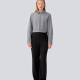 Let cropped jakke i 80% uld. LissieMD jacket er grå, har en klassisk krave, lynlås lukning fortil og manchet med trykknap. Modellen er 177 cm og har en størrelse S/36 på.