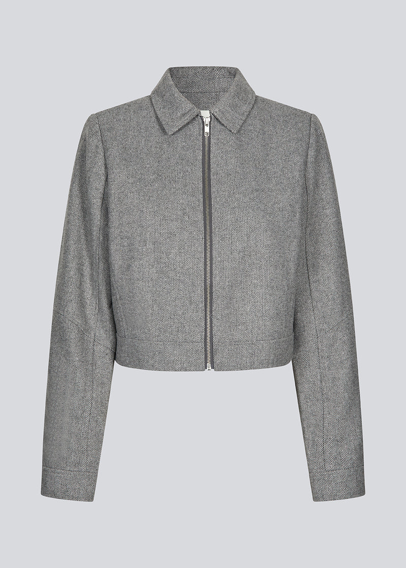 Let cropped jakke i 80% uld. LissieMD jacket er grå, har en klassisk krave, lynlås lukning fortil og manchet med trykknap. Modellen er 177 cm og har en størrelse S/36 på.