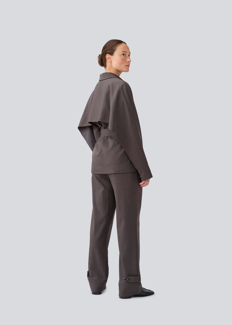 Klassisk mørkegrå blazer med skjorte krave og bindebånd. LonnieMD blazer har to lommer, knappelukning fortil samt et dekorativt bærestykke på ryggen.