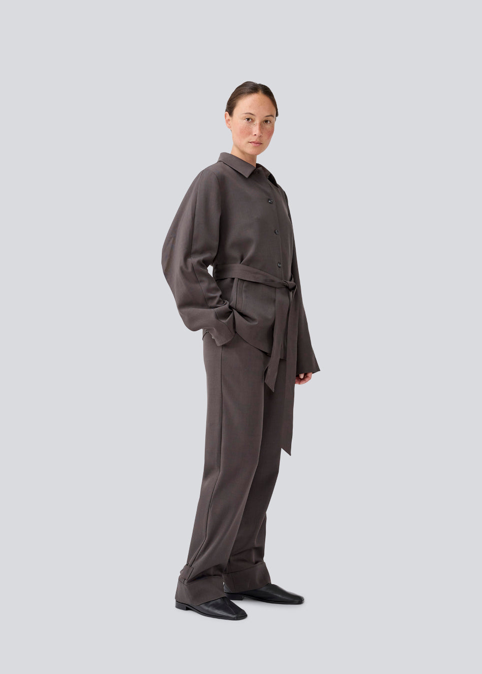 Klassisk mørkegrå blazer med skjorte krave og bindebånd. LonnieMD blazer har to lommer, knappelukning fortil samt et dekorativt bærestykke på ryggen.