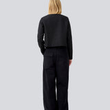 Kort sort jakke i struktureret materiale. LuniMD jacket har to lommer fortil og knappelukning med beklædte knapper. Modellen er 177 cm og har en størrelse S/36 på.