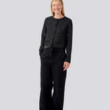 Kort sort jakke i struktureret materiale. LuniMD jacket har to lommer fortil og knappelukning med beklædte knapper. Modellen er 177 cm og har en størrelse S/36 på.