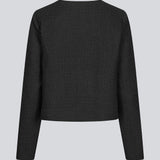 Kort sort jakke i struktureret materiale. LuniMD jacket har to lommer fortil og knappelukning med beklædte knapper. Modellen er 177 cm og har en størrelse S/36 på.