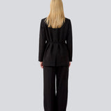 Klassisk sort blazer med oversize pasform og et bindebånd i taljen. LykkeMD blazer har en satin detalje på kraven og en slids bagpå. Modellen er 177 cm og har en størrelse S/36 på.