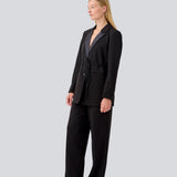 Klassisk sort blazer med oversize pasform og et bindebånd i taljen. LykkeMD blazer har en satin detalje på kraven og en slids bagpå. Modellen er 177 cm og har en størrelse S/36 på.
