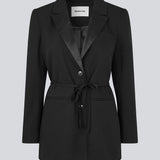 Klassisk sort blazer med oversize pasform og et bindebånd i taljen. LykkeMD blazer har en satin detalje på kraven og en slids bagpå. Modellen er 177 cm og har en størrelse S/36 på.