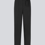 Sorte habitbukser med bindbånd i taljen. LykkeMD pants har gylp med lynlås og knap, sidelommer og paspolerede baglommer. Modellen er 177 cm og har en størrelse S/36 på.