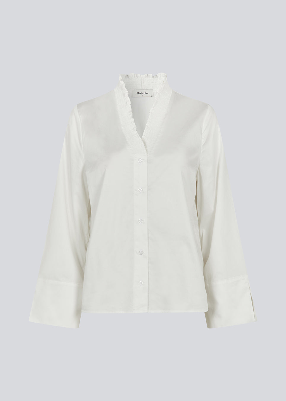Løs hvid skjorte med v-udskæring med smock detalje. LylaMD shirt har lange brede ærmer med slids og en knaplukning fortil.