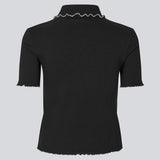 Figursyet polo i sort med hvis kanter i jersey. MagdaloneMD polo har korte ærmer og overlockede kanter. Modellen er 177 cm og har en str. S/36 på.