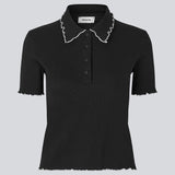 Figursyet polo i sort med hvis kanter i jersey. MagdaloneMD polo har korte ærmer og overlockede kanter. Modellen er 177 cm og har en str. S/36 på.