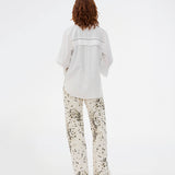 Oversize hvid skjorte med broderie anglaise detaljer. MallenMD shirt har brede ærmer med slids, skjorte krave og knappelukning fortil. 
