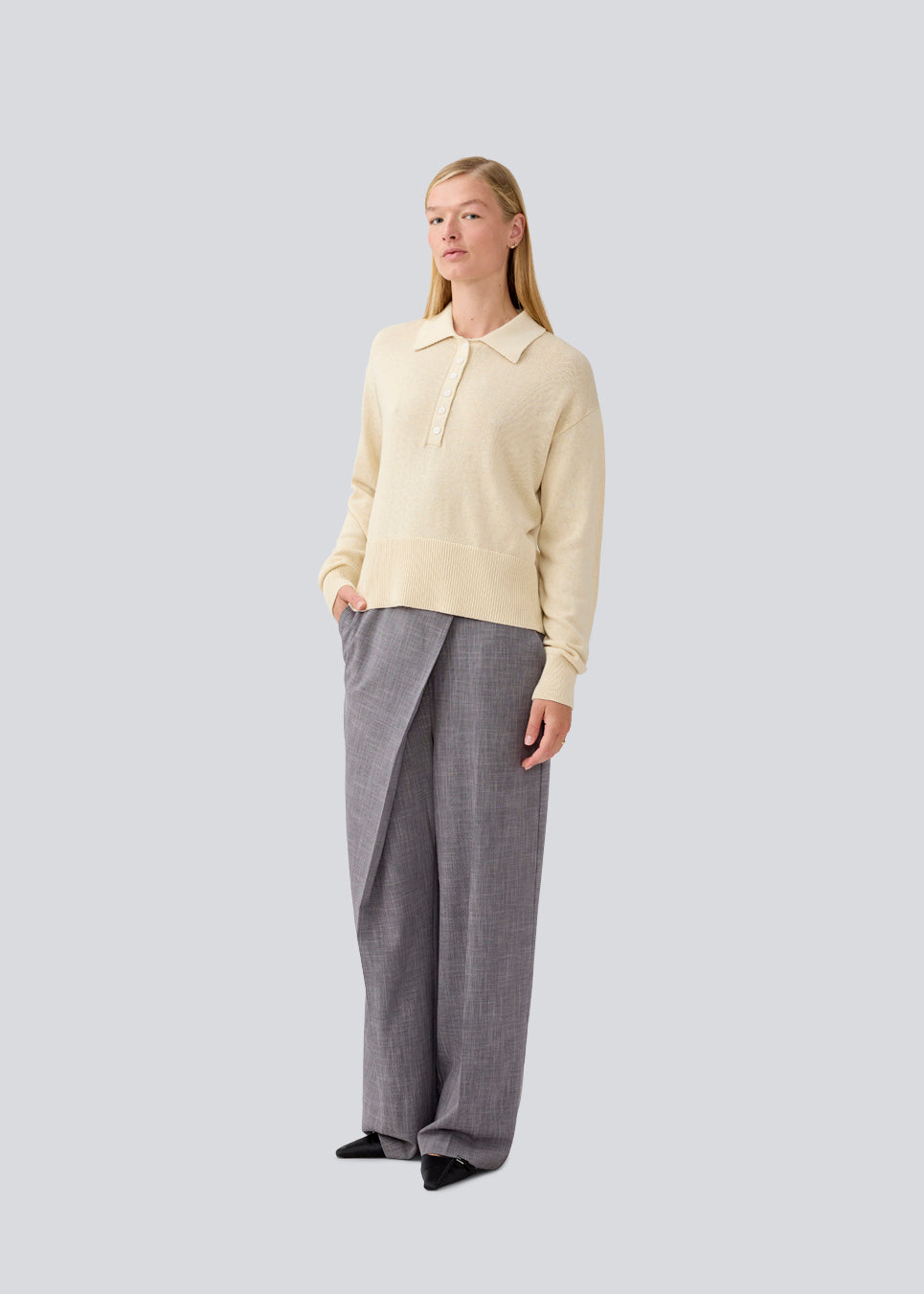 Blød strikket polo i beige. MalvaMD polo har en krave med stolpe lukning. Strikken er lille i størrelsen, og kort. Modellen er 177 cm og har en str S/36 på.