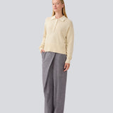 Blød strikket polo i beige. MalvaMD polo har en krave med stolpe lukning. Strikken er lille i størrelsen, og kort. Modellen er 177 cm og har en str S/36 på.