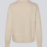 Blød strikket polo i beige. MalvaMD polo har en krave med stolpe lukning. Strikken er lille i størrelsen, og kort. Modellen er 177 cm og har en str S/36 på.