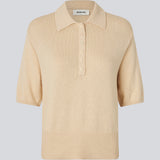 Blød strikket polo i beige i 100% bomuld. MalvaMD SS polo har en krave med stolpelukning og korte ærmer.